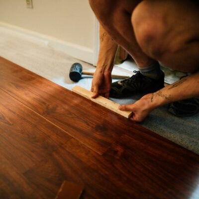 Crop man installing laminate flooring